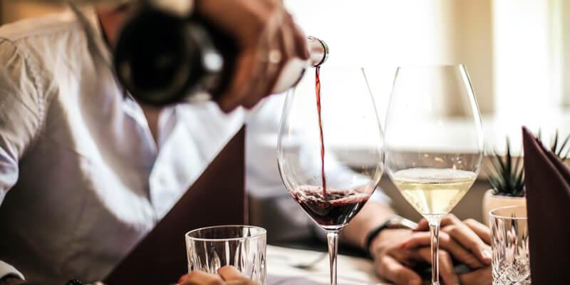 Man pouring wine in glasses